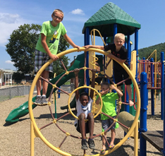 Three students on playground equipment