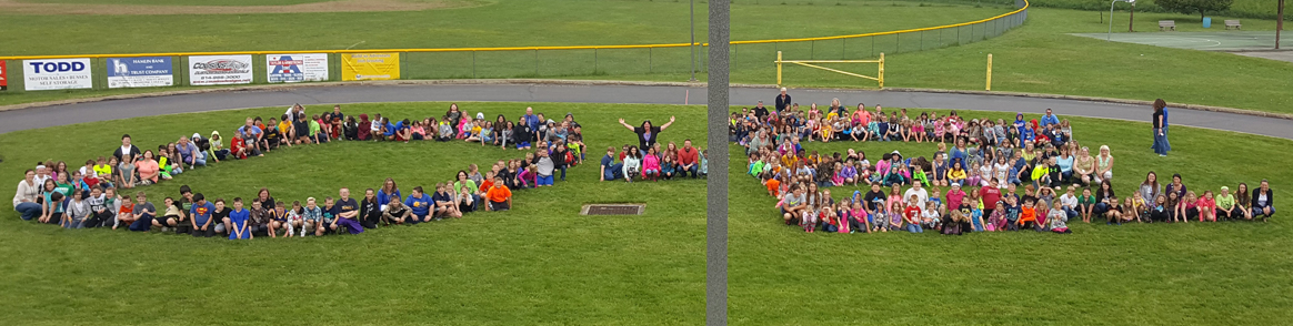 Students form the letters O and E with their bodies outside