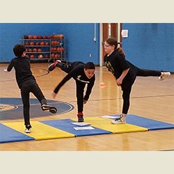 three students on a workout mat