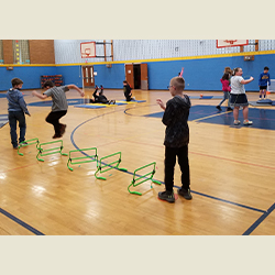 students jumping over hurdles